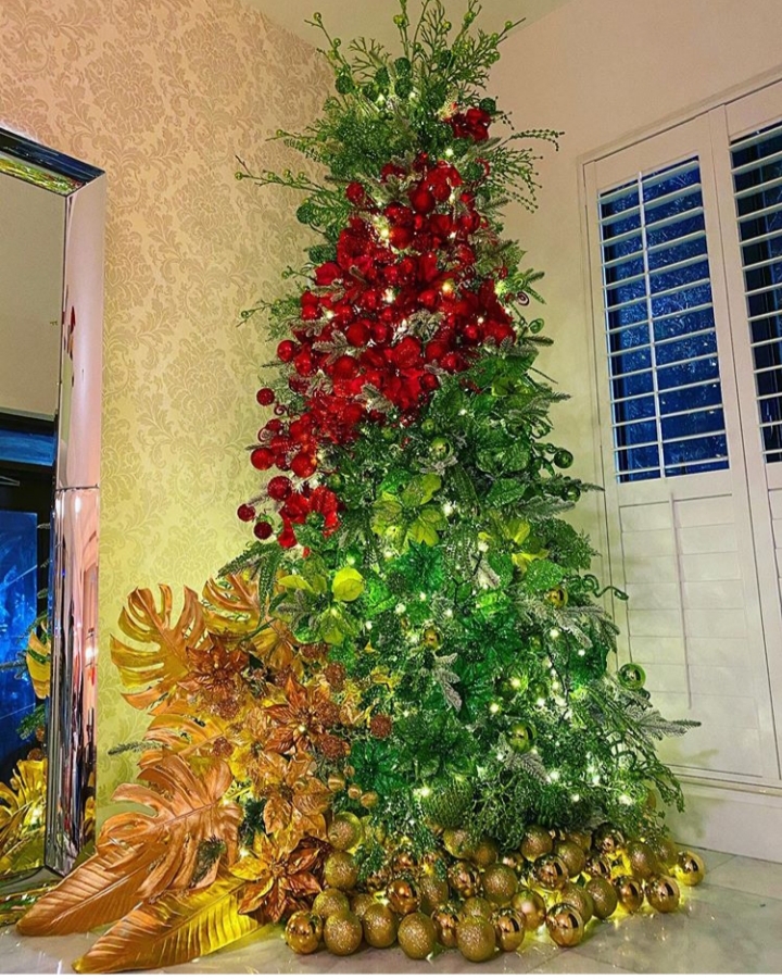 Árbol navideño con hojas doradas y ornamentos premium
